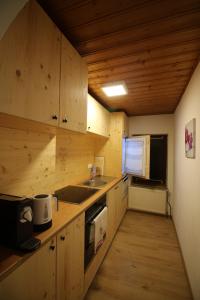 伊布斯河畔魏德霍芬Bio Bauernhof - Mini Shetland Ponyhof "Almbauer"的厨房配有木制橱柜、水槽和微波炉