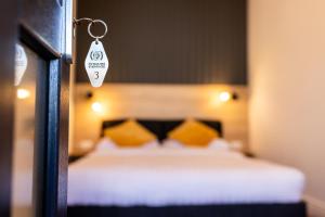 胡内多阿拉Corvin Guesthouse的一间卧室配有一张带黄色枕头的床和钥匙链。