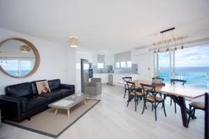 黄金海岸Grosvenor Beachfront Apartments Surfers Paradise的客厅配有黑色沙发和桌子