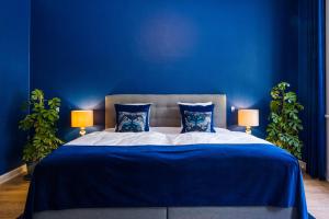 Augustenborg'Gem Suites Luxury Holiday Apartments的蓝色卧室设有一张带蓝色墙壁的大床
