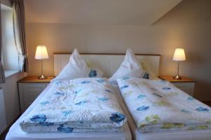 纽哈灵吉塞尔Ferienwohnungen Peters的一间卧室配有两张带枕头和两盏灯的床。