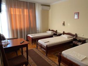 佩特里奇Family Hotel "May"的酒店客房带两张床和一张桌子以及椅子。