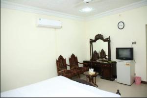 木尔坦Hotel OR Odyssey Residence的一间卧室配有一张床、一台电视和一面镜子