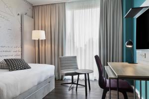 嘉兴贝慕尼黑Stellaris Apartment Hotel的酒店客房带一张床、一张桌子和椅子