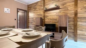 大特尔诺沃Апартхотел Конниците的一间带桌子和木墙的用餐室