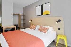 布鲁瓦Appart'City Classic Blois的一间卧室配有床和黄色凳子