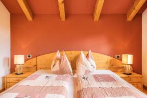 科利因普斯泰里亚Oberplunerhof - Fewo Bruneck的一间卧室配有两张带枕头和两盏灯的床。