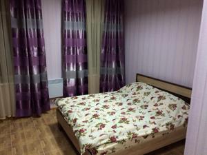 KonotopShangHai Hotel的卧室内的一张床位,配有紫色窗帘