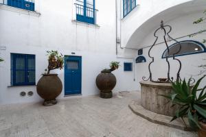 卡普里Qasar Luxury Suite - in Capri's Piazzetta的庭院,带两个大花瓶和一扇蓝色门