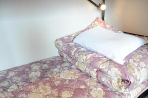 大阪04 village Namba Mixed Dormitory room - Vacation STAY 64862v的一张带鲜花毯子和枕头的床