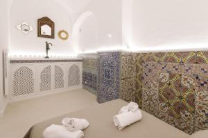 卡普里Qasar Luxury Suite - in Capri's Piazzetta的浴室提供2条毛巾和马赛克墙