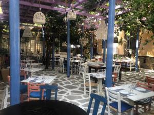 阿基欧斯尼古拉斯Big Blue Luxury Apartment的一间设有桌椅和树木的餐厅