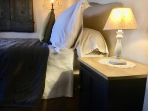 皮恩扎Vento d’Orcia的一间卧室配有一张床和一张带台灯的桌子