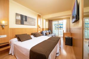 罗列特海岸Hotel Guitart Central Park Aqua Resort的酒店客房设有一张大床和一台电视。