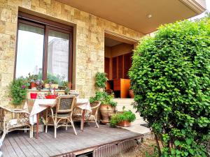 塞萨洛尼基Antony Luxury Suite in Thessaloniki的一个带桌椅和大灌木的庭院