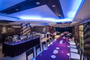 库克斯巴扎Prime Park Hotel的一间设有紫色桌椅的餐厅和一间酒吧