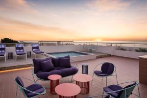 开普敦Home Suite Hotels Sea Point的带家具的屋顶露台和游泳池