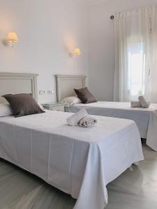 塞维利亚多尼亚布兰卡酒店的白色墙壁客房的两张床