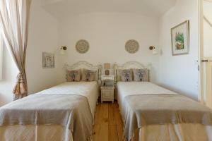 埃尔瓦斯Casa do Povo的配有白色墙壁和木地板的客房内的两张床