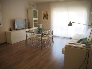 桑特费柳德吉克索尔斯Apartament per families a Sant Feliu amb piscina的客厅配有玻璃桌和电视