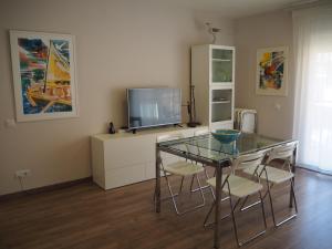桑特费柳德吉克索尔斯Apartament per families a Sant Feliu amb piscina的一间带玻璃桌和电视的用餐室