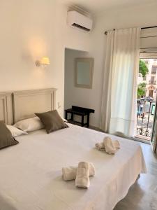 塞维利亚多尼亚布兰卡酒店的卧室配有一张白色大床和两条毛巾