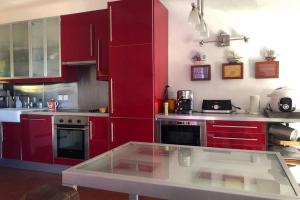 博尔马斯·莱斯·米默萨斯Magnifique maison de village clim vue mer 6 pers的一间厨房,配有红色橱柜和台面