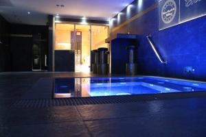 亚诺夫纳德尼索Wellness Chata Brejlovka的大楼内带蓝色浴缸的大型游泳池