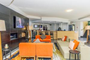 堪培拉堪培拉阿尔法酒店的带沙发和橙色椅子的客厅
