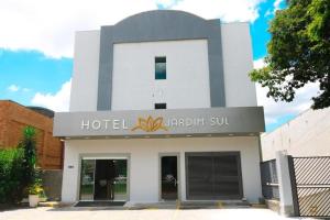 圣若泽杜斯坎普斯Hotel Jardim Sul的一座白色的建筑,上面有酒店标志
