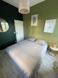 塞里斯superbe villa au pied de Disneyland et val d'Europe的一间卧室,在绿色的墙上配有一张大床