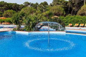 米兰马瑞提那阿德里亚酒店的游泳池中间设有遮阳伞