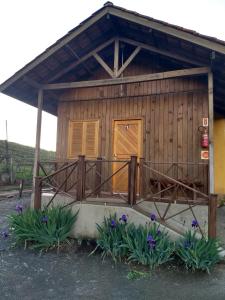 乌鲁比西Chales Manaca da Serra的小屋设有种有紫色花卉的门廊