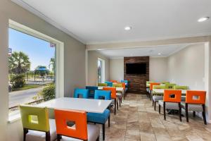 萨凡纳Days Inn by Wyndham Savannah Gateway I-95的一间设有五颜六色的椅子和桌子的等候室