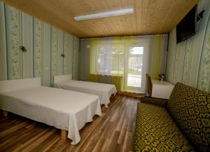 Puise普西尼娜酒店的客房设有两张床、一张沙发和一个窗口。