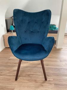 海尔布隆Boardinghouse Heilbronn的一张带木腿的蓝色天鹅绒椅子