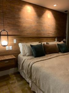 伊泰帕瓦Granja Brasil的一间卧室设有一张带木墙的大床