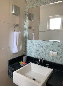 库里提巴Suite residencial, Villa da Luz的浴室设有白色水槽和镜子