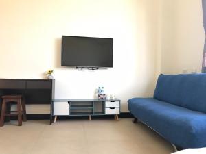金宁乡东一点紅金墩园的客厅配有蓝色的沙发和电视