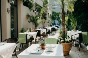 萨尔布吕肯水晶酒店的餐厅拥有白色的桌椅和棕榈树