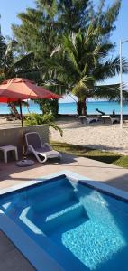 贝圣安那考特多尔足迹旅馆的海滩旁的蓝色游泳池,带遮阳伞