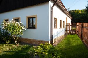 MezimestiChalupa Barborka的白色的房子,有栅栏和院子