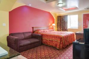 奥兰治天空棕榈汽车旅馆 - 橙色的红色卧室配有床和椅子