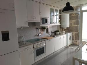 蒙达里斯-瓦尔内亚里奥Residencial Mondariz Balneario 424的白色的厨房配有白色橱柜和水槽