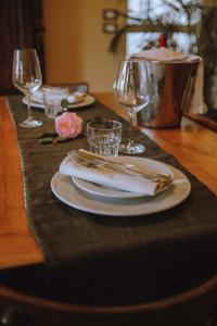 PettinengoLa Foresteria di Villa Piazzo的餐桌,带餐盘和餐巾及酒杯