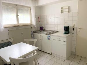 马克多夫FeWo25-Zimmer-am-Bodensee的白色的小厨房,配有桌子和柜台