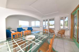 伊斯基亚Villa Stefania的客厅配有玻璃桌和椅子