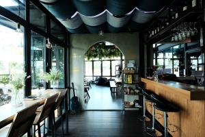 曼谷廊曼机场维哈旅舍的餐厅设有酒吧,配有椅子和窗户