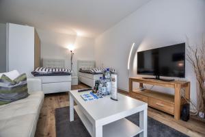 科隆Domicile Cologne的客厅配有白色沙发和电视
