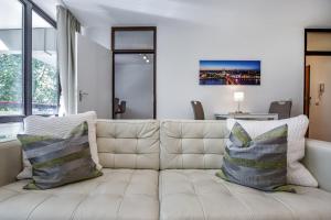 科隆Domicile Cologne的客厅配有带枕头的白色沙发